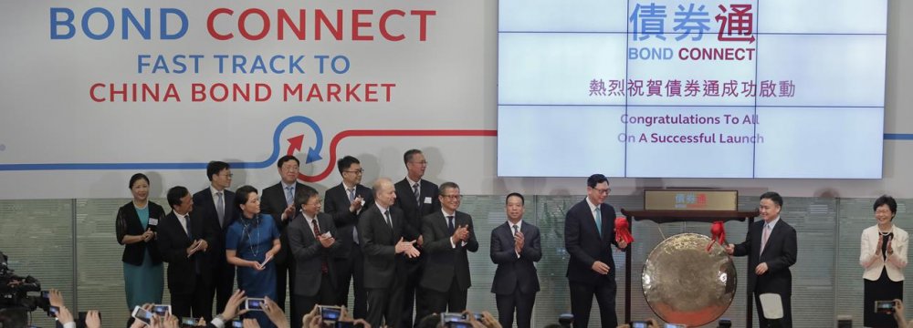 From right, Hong Kong’s new Chief Executive Carrie Lam claps hands as PBoC Deputy Governor Pan Gongsheng and Hong Kong Monetary Authority Chief Executive Norman Chan beat a gong to launch the Bond Connect in Hong Kong, July 3.