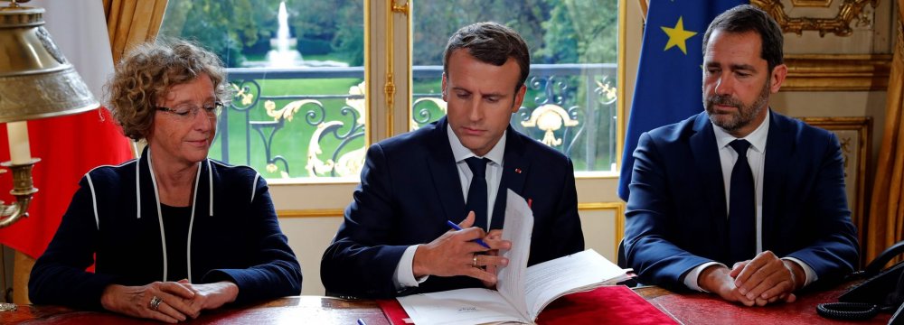 President Emmanuel Macron (C) signs a set of executive orders making sweeping changes to France’s complex labor laws on Friday.