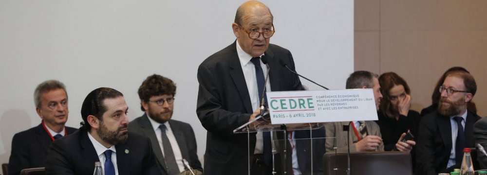 French Foreign Minister Jean-Yves Le Drian addresses CEDRE Conference in Paris on April 6, with Lebanese Prime Minister Saad Hariri on his right. 