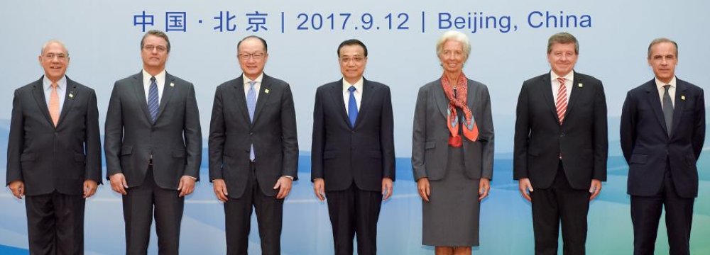 (L-R) OECD Secretary-General Angel Gurria, WTO Director-General Roberto Azevedo, WB President Jim Yong Kim, Chinese Premier Li Keqiang, IMF Chief Christine Lagarde, ILO Director-General Guy Ryder and G20’s Chairman Mark Carney in Beijing’s Diaoyutai State Guesthouse, on September 12.