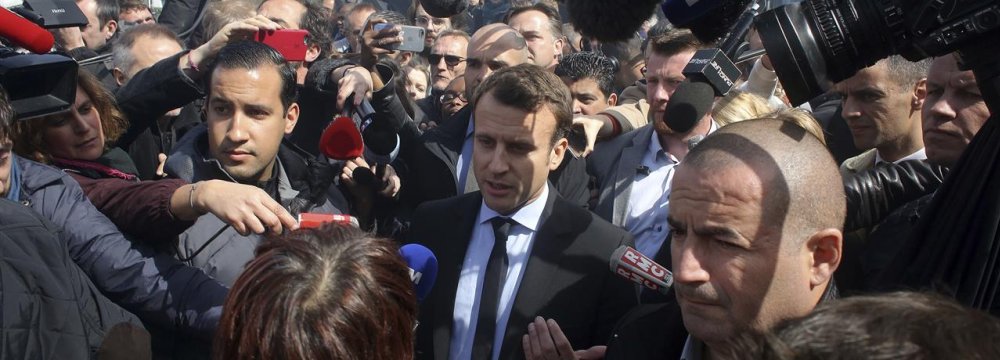 French President Emmanuel Macron (C) has vowed to give more freedom to companies negotiating wage deals with labor unions, to restore tax benefits on overtime, and to encourage social mobility by subsidizing the hiring of people from France’s most deprived areas.