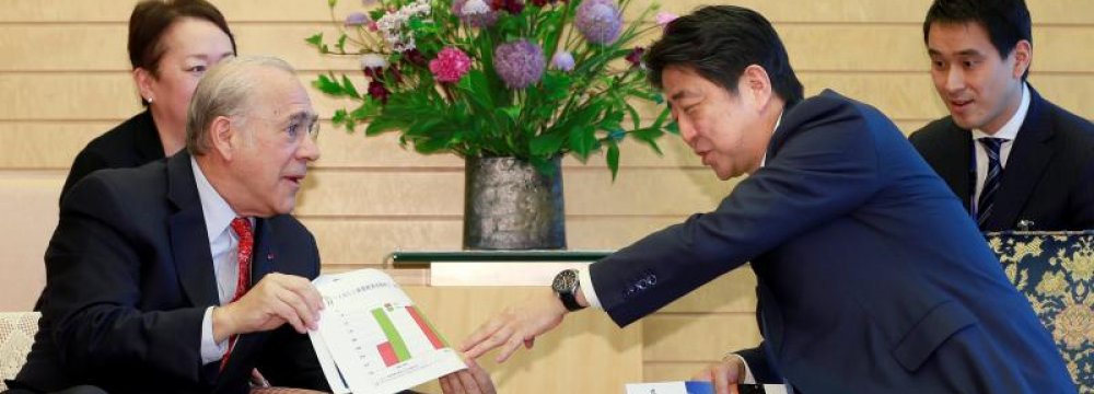 OECD Secretary-General Angel Gurria (L), explains materials of OECD Economic Surveys Japan to Japanese Prime Minister Shinzo Abe at Abe’s official residence in Tokyo, April 13.