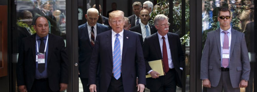 President Trump (C) along with his national security advisor, John Bolton (R) leave the G7 meeting earlier than scheduled.