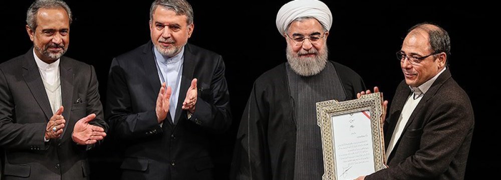 President Hassan Rouhani (2nd R), Culture Minister Reza Salehi Amiri (2nd L) and Mohammad Nahavandian,  chief of presidential staff, (L) with one of the winners at Vahdat Hall on February 7