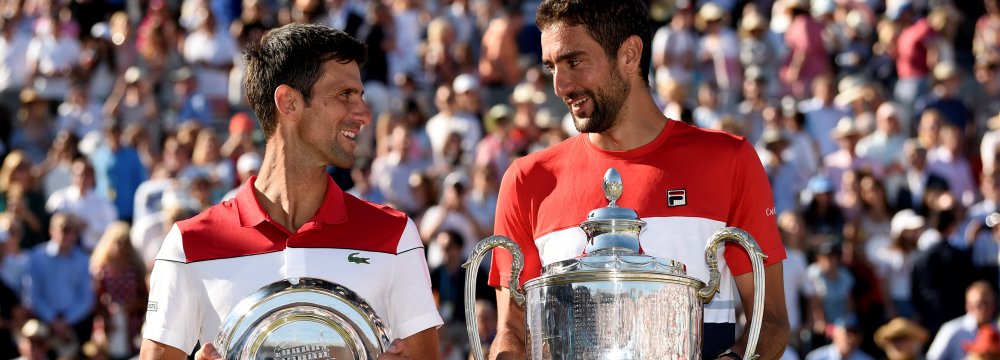 Marin Cilic (R) poses with the trophy after winning the final against Novak Djokovic on Sunday.