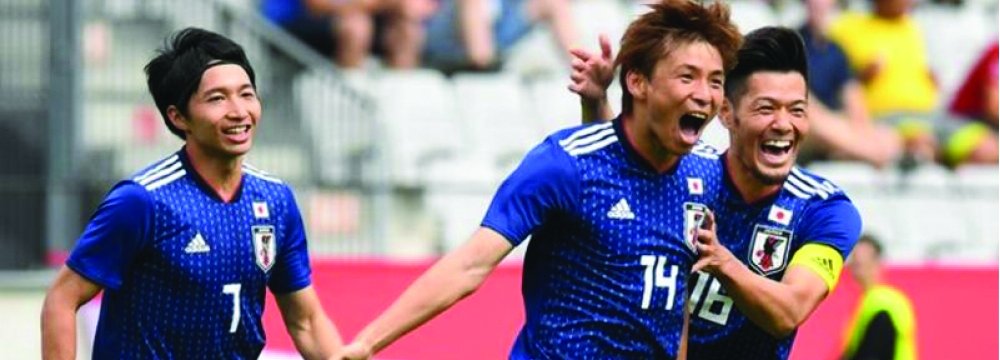 Japan players celebrate a goal.