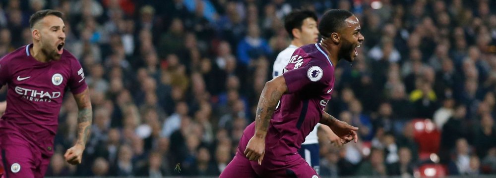 Manchester City’s Raheem Sterling (R) celebrates scoring  his side’s third goal against Tottenham Hotspur.