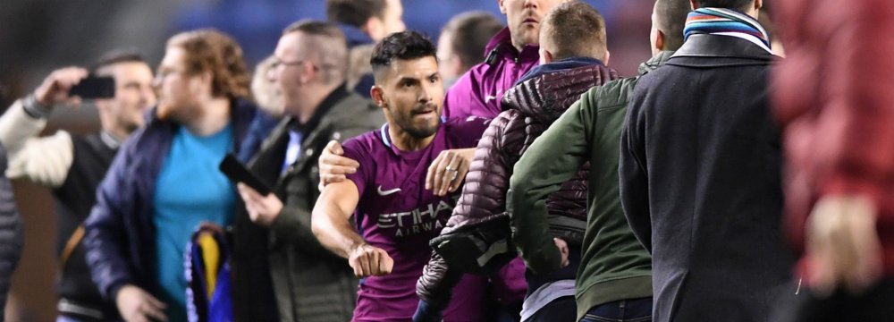 Sergio Aguero clashes with Wigan fans after their invasion  of the pitch.