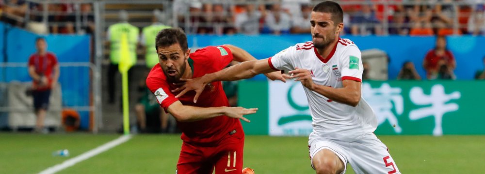 Milad Mohammadi (R) vies for the ball with Bernardo Silva during Iran-Portugal match in FIFA World Cup Russia.