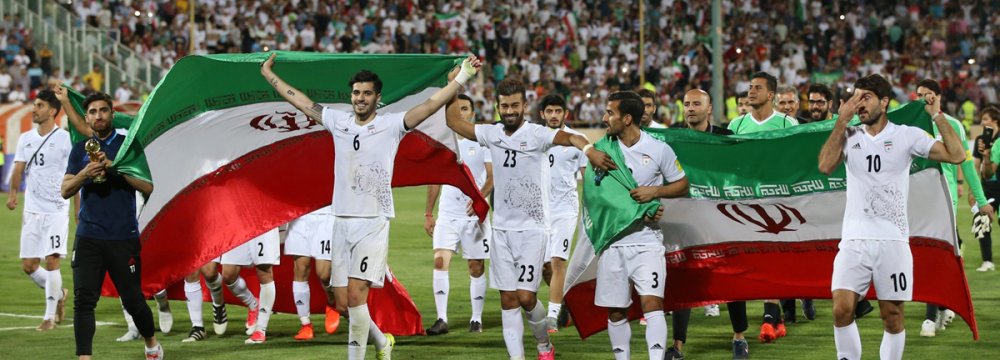 Iranian players celebrate after winning the 2018 World Cup qualifying football match against Uzbekistan at Azadi Stadium in Tehran on June 12.