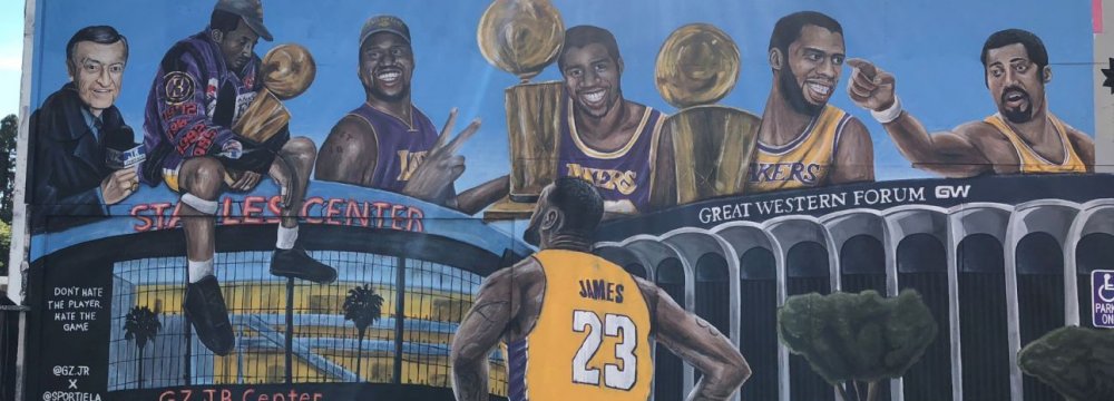 The mural in LA shows LeBron James looking up at several Lakers stars and  its historic venues.