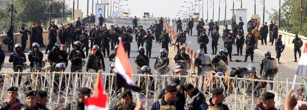 Riot police stand in front of demonstrators during the protest near Baghdad’s Green Zone on Feb. 11.