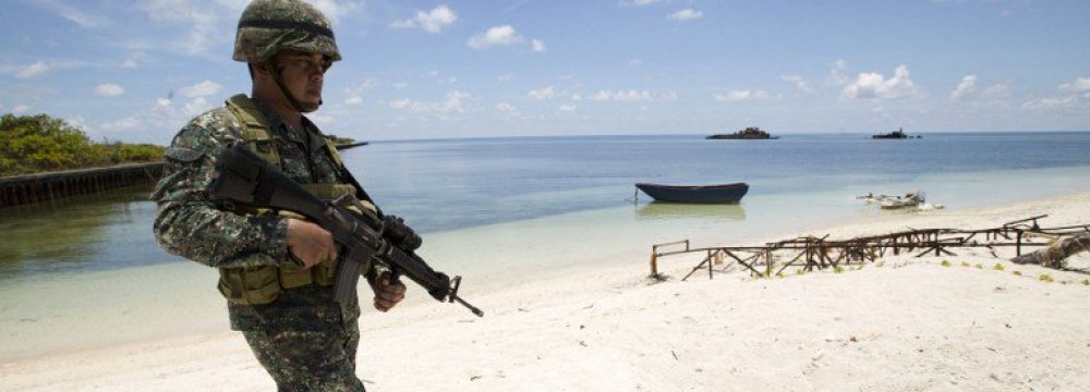 A Philippine soldier patrols a beach on Pagasa Island at the Spratly group of islands in South China Sea, west of Palawan. (File Photo)