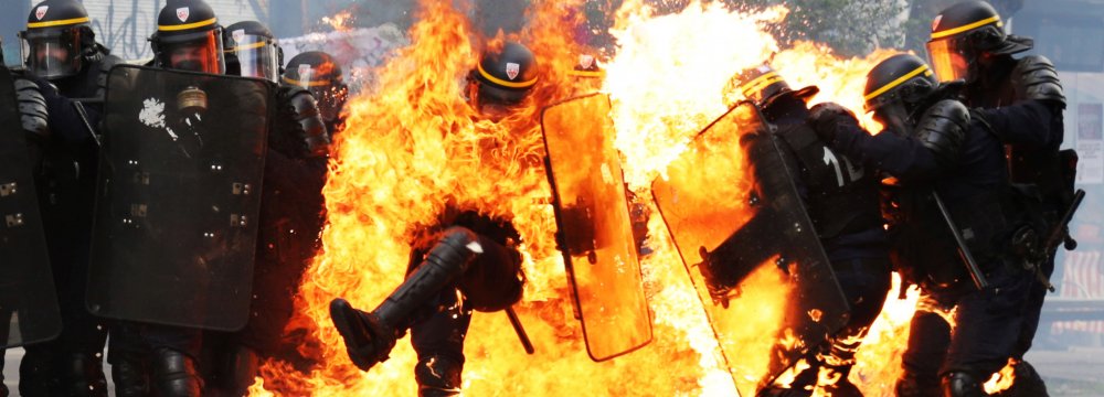 One riot police officer engulfed in flames in Paris, France, on May 1.
