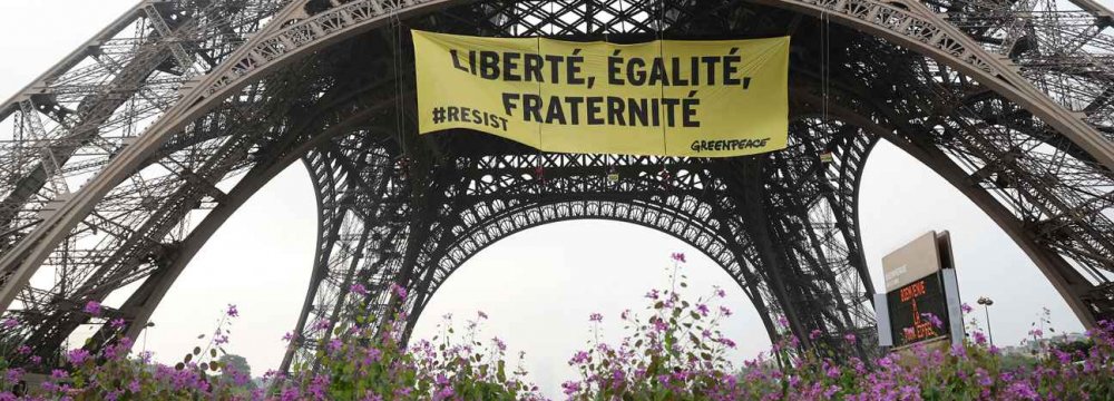 In a major security breach, Greenpeace activists partially scaled the Eiffel Tower to hang a giant anti-Le Pen banner in Paris, France, on May 5.