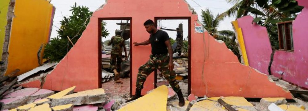 A member of the military inspects a damaged house  in Colombo, Sri Lanka, on April 15.