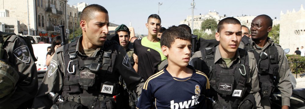 Israeli soldiers arrest a young Palestinian boy. (File Photo)