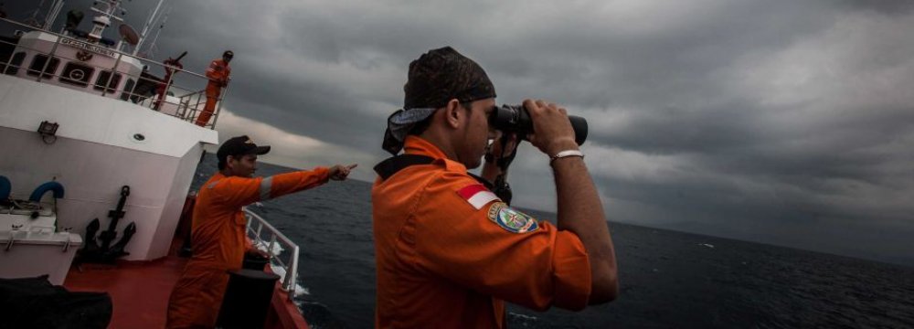 An Indonesian search and rescue member looks through binoculars during a search in the Andaman Sea. (File Photo)