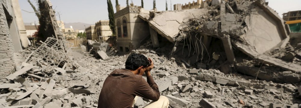 Man sits on the rubble after a Saudi-led coalition airstrike.