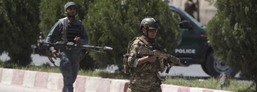 Afghan security personnel get into position at the site  of an attack on the Interior Ministry in Kabul on May 30.