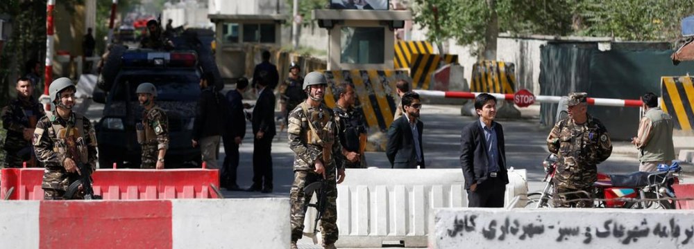 Afghan security forces stand guard near the site of a blast in Kabul on April 30.