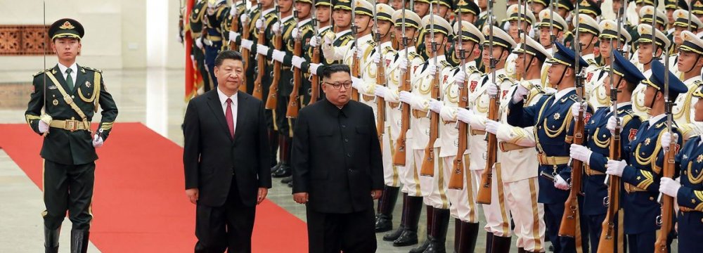 Kim Jong-un (R) inspecting an honor guard while accompanied by Chinese President Xi Jinping during a welcoming ceremony at the Great Hall of the People in Beijing on June 19.