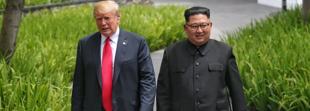 US President Donald Trump walks with North Korean leader Kim Jong-un  at the Capella Hotel on Sentosa island in Singapore on June 12.  