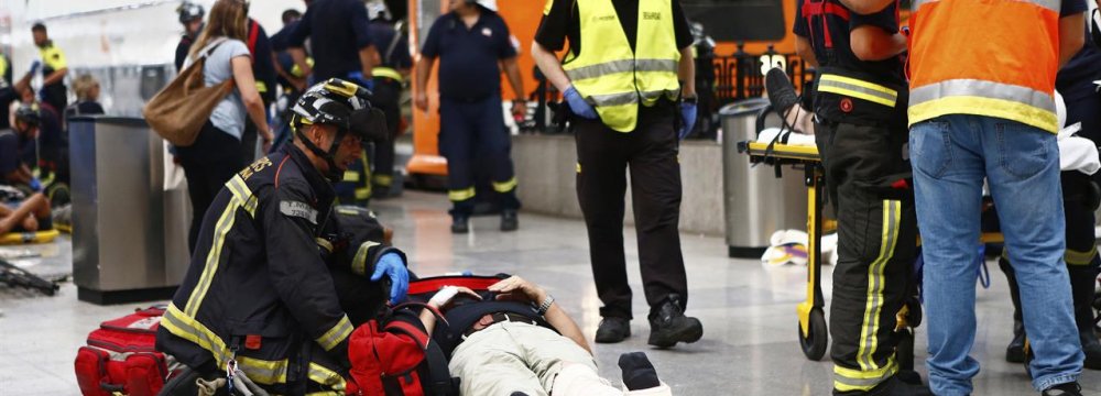 An injured passenger is attended to on the platform of a train station in Barcelona, Spain, July 28.