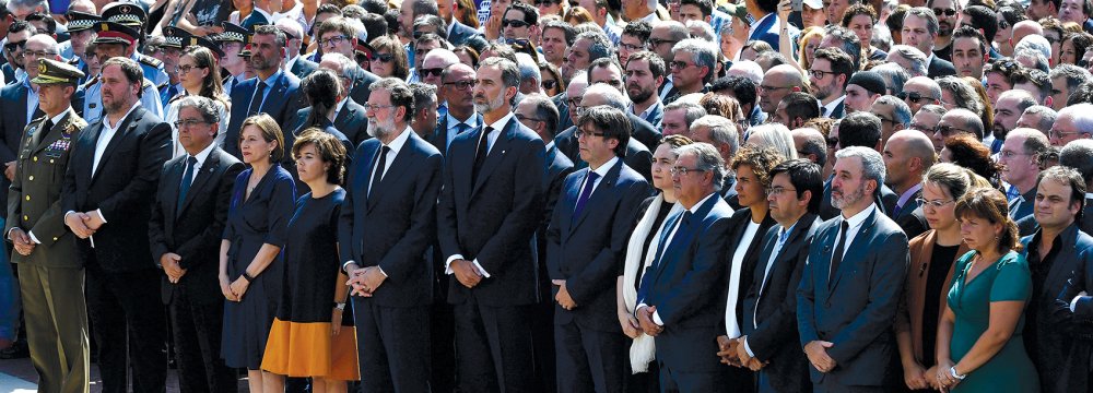 Catalan regional vice-President and chief of Economy and Finance, Oriol Junqueras (2ndL), Spain’s King Felipe VI (7thL), Spanish Prime Minister Mariano Rajoy (6thL), President of Catalonia Carles Puigdemont (9thR), Spanish vice-President of the Government and Minister of the Presidency and of the Regional Administrations Soraya Saenz de Santamaria (5thL), Barcelona’s mayor Ada Colau (8thR), President of the Catalan parliament Carme Forcadell (4thL) and officials observe a minute of silence for the victims o