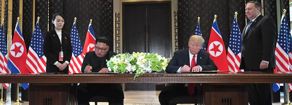 US President Donald Trump and North Korea's leader Kim Jong-un sign documents as US Secretary of State Mike Pompeo (R) and the North Korean leader's sister Kim Yo Jong (L) look on at a signing ceremony during the US-North Korea summit, at the Capella Hotel on Sentosa island in Singapore on June 12.