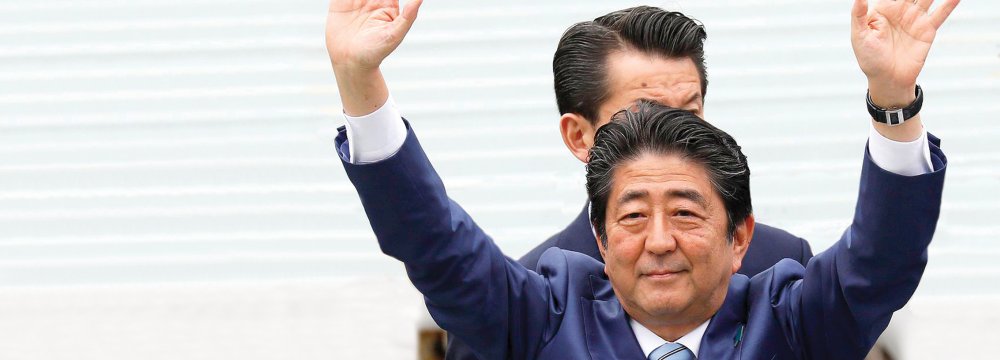 Japan’s Prime Minister Shinzo Abe waves to the audience following his speech during an election campaign in Tokyo.