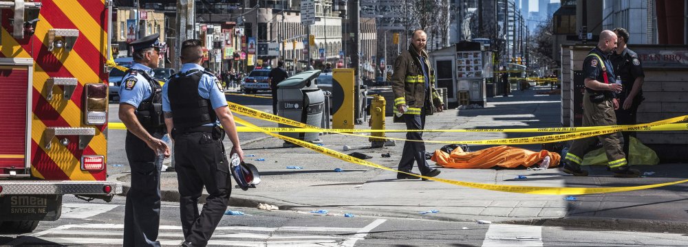A body lies covered on the sidewalk in Toronto after a van mounted a sidewalk crashing into a number of pedestrians on April 23.