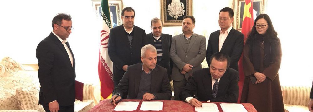 The agreement with Chinese lenders was signed in Beijing in the presence of Iran’s Health Minister Hassan Qazizadeh Hashemi (back left).
