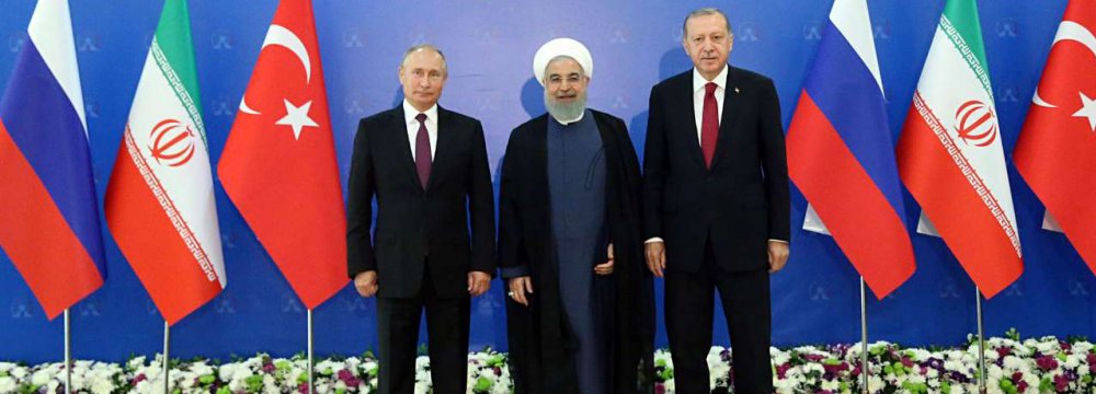 President Hassan Rouhani (C) stands next to Russian President Vladimir Putin (L) and Turkish President Recep Tayyip Erdogan ahead of a trilateral summit in Tehran on Friday.