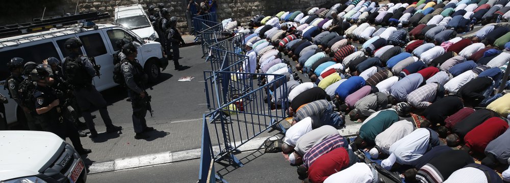 Muslim worshippers pray perform the traditional Friday prayers on a street outside the Lion Gate as Israeli police blocks the access to Al-Aqsa Mosque on July 14.