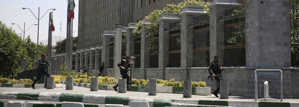 Police forces run to take position around the parliament building after an assault of several attackers, in Tehran on June 7.