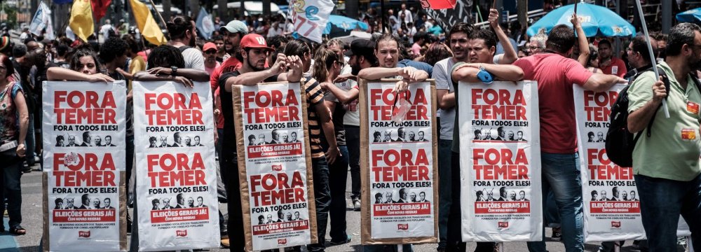 Protesters hold placards reading ‘Temer Out’ during a demonstration against austerity measures in Rio de Janeiro, Brazil.