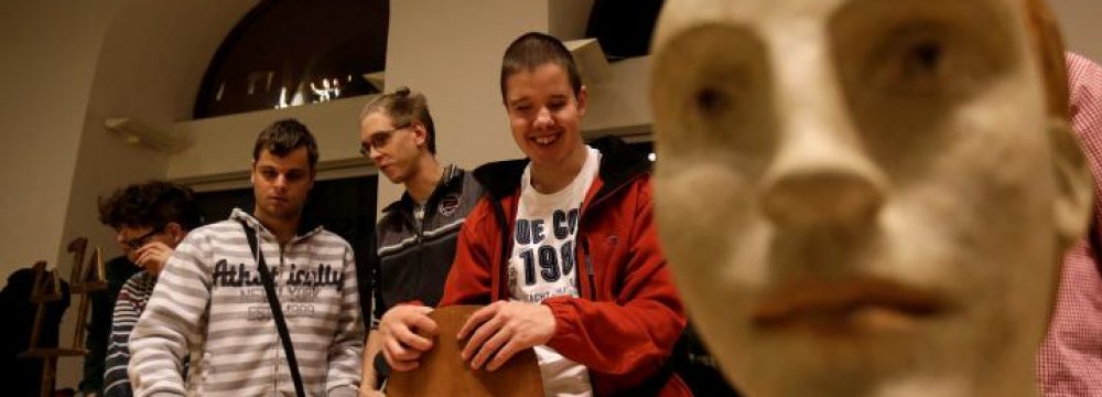 Blind people touch sculptures during a special exhibition for people with visual disabilities in Prague, Czech Republic.