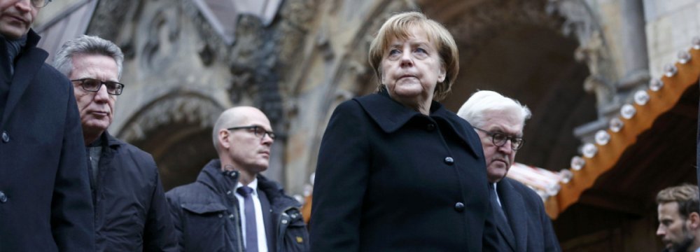 Chancellor Angela Merkel observes a minute’s silence at the scene of the carnage in Berlin. 