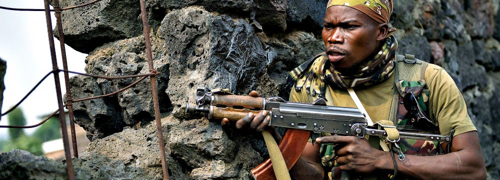 A Congolese soldier positions himself behind a wall during a firefight.