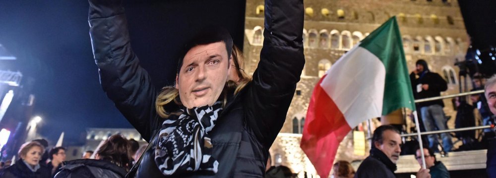 A woman wears a mask of Italian Premier Matteo Renzi as she holds up a sign reading “Yes” during a rally in Florence, Italy, on Dec. 2.