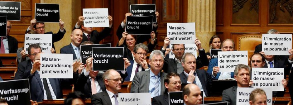 Members of the conservative right Swiss People’s Party held up signs that read “breach of the constitution” and “mass immigration continues”.