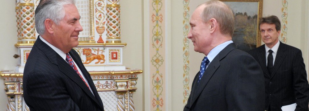 Vladimir Putin (R) shakes hands with Rex Tillerson at a meeting in April 2012. (File Photo)