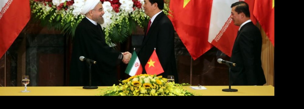 President Hassan Rouhani (L) shakes hands with Vietnamese President Tran Dai Quang in Hanoi, Vietnam, on Oct 6.