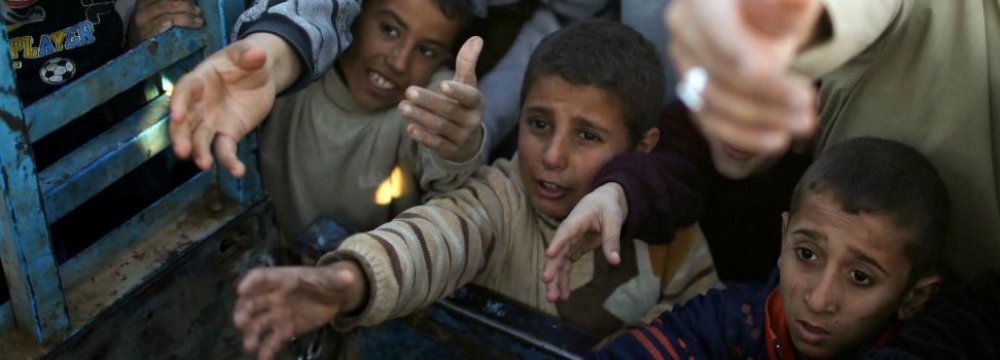 Displaced Iraqi boys ask for food at a food distribution point in Khazer camp, Iraq, on Nov. 21. 