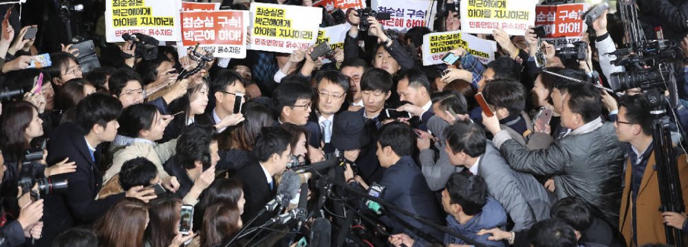 Choi Soon-sil (C), who is involved in a political scandal, reacts as she is surrounded by media and protesters upon her arrival at a prosecutor’s office in Seoul, South Korea, on Oct 31.