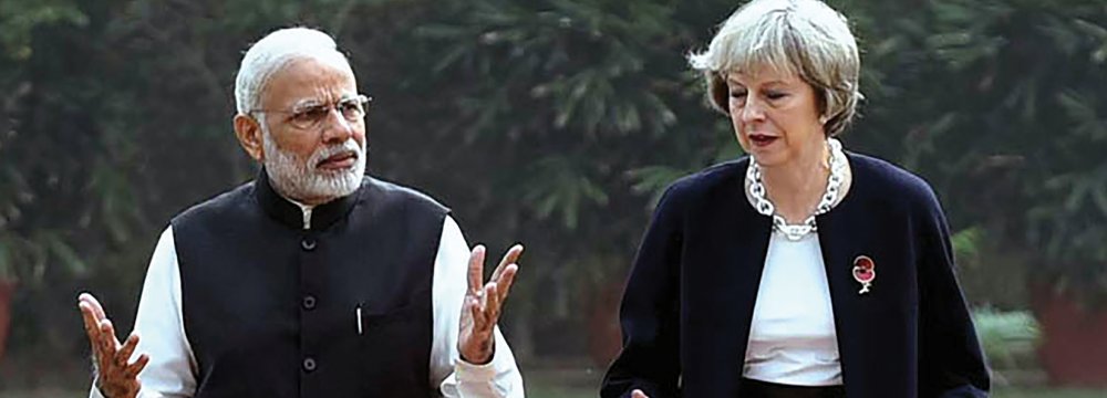 Prime Minister Narendra Modi (L) walks with Britain’s Prime Minister Theresa May at Hyderabad House in New Delhi. May described as “limitless” the potential of the relationship with India.