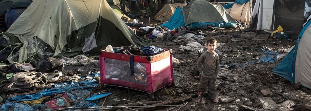 A five-year-old Kurdish boy from Iraq stands amid rubbish in the Calais camp.