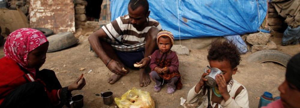 A family eats breakfast outside their hut at a camp for people displaced by the war near Sana’a on Sept. 26, 2016. (File Photo)