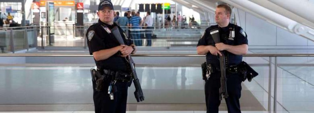 Port Authority police officers stand guard near a departures entrance at John F. Kennedy International Airport in New York on Aug. 14.